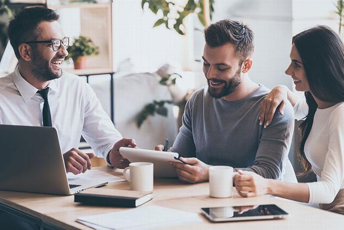 A mortgage adviser discussing options with a couple in a professional office setting.