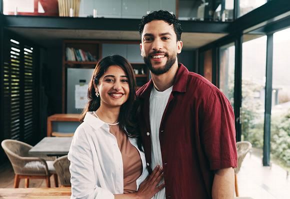 Happy couple smiling together in a modern home, showcasing a warm and inviting atmosphere.